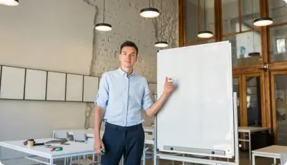 Personne devant un tableau, marqueur à la main